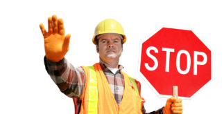 A construction worker stopping traffic, holding a stop sign.  Isolated on white.