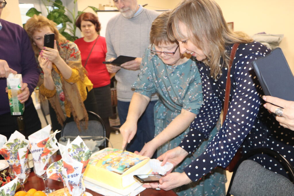 Вера Гроховская и Ольга Корельская режут торт в виде книги "Поиграем". 